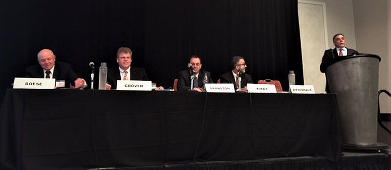 A group of men sitting at a table with their names on it