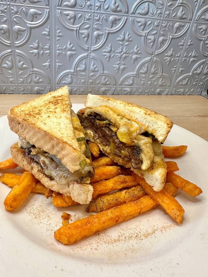 A sandwich and french fries on a white plate.