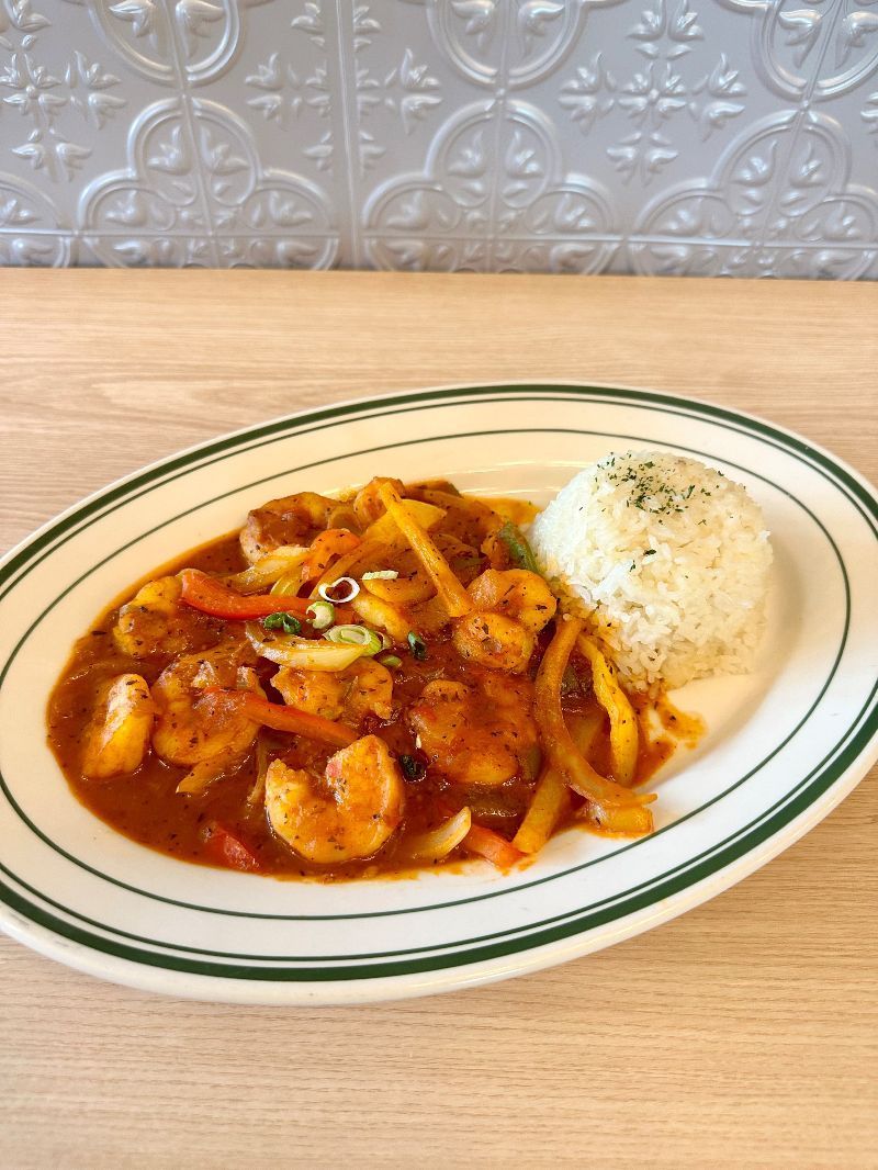 A plate of food with shrimp and rice on a table.