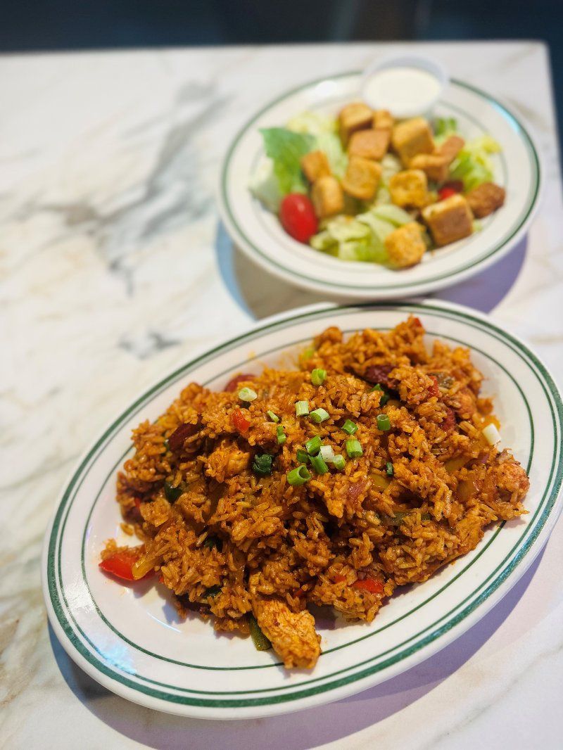 Two plates of food and a salad on a table.