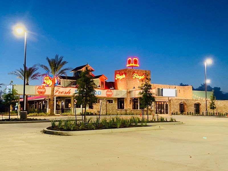 An empty parking lot in front of a restaurant at night