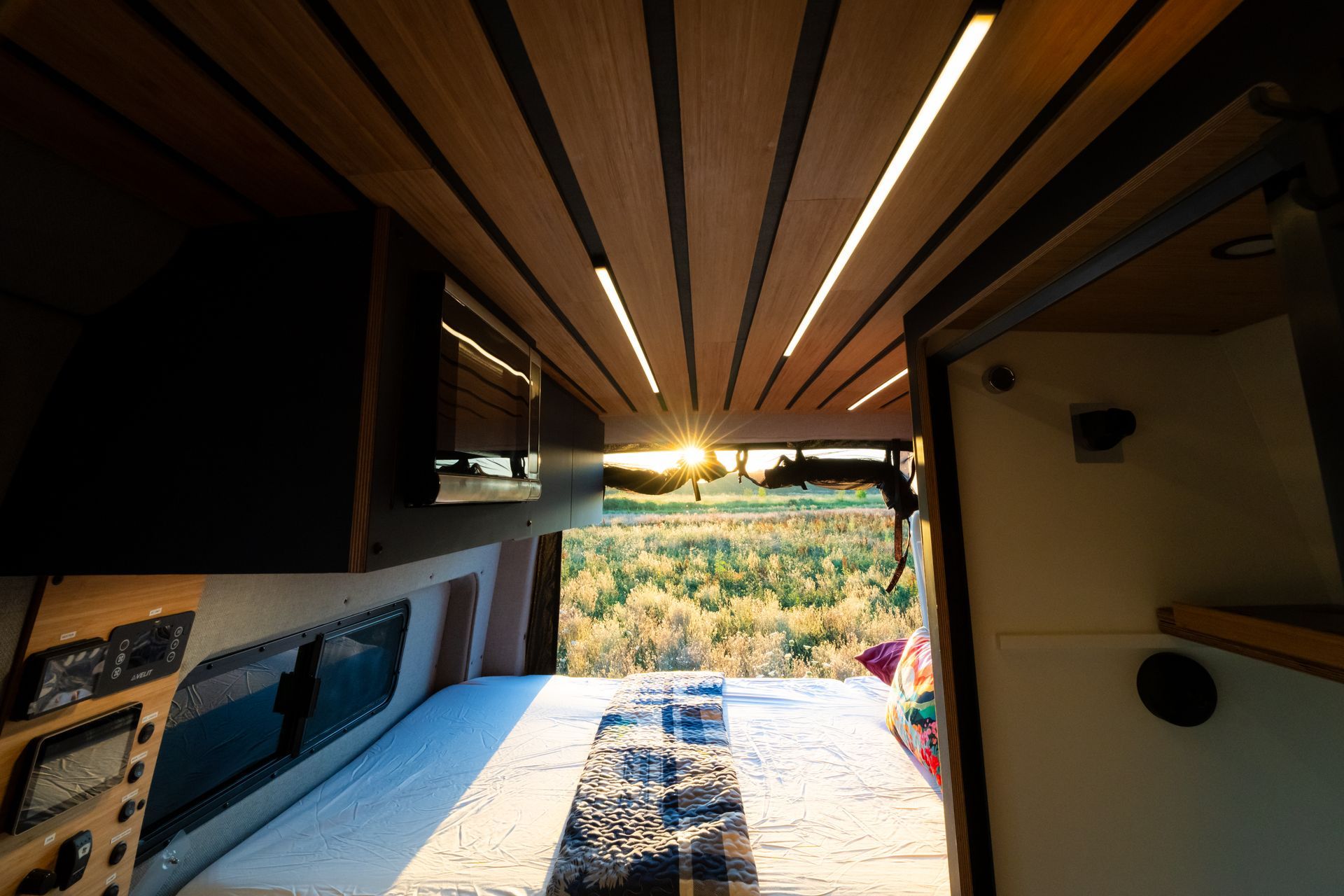 Sunlit outdoor patio with wood ceiling, built-in bench, and mountain view at sunset