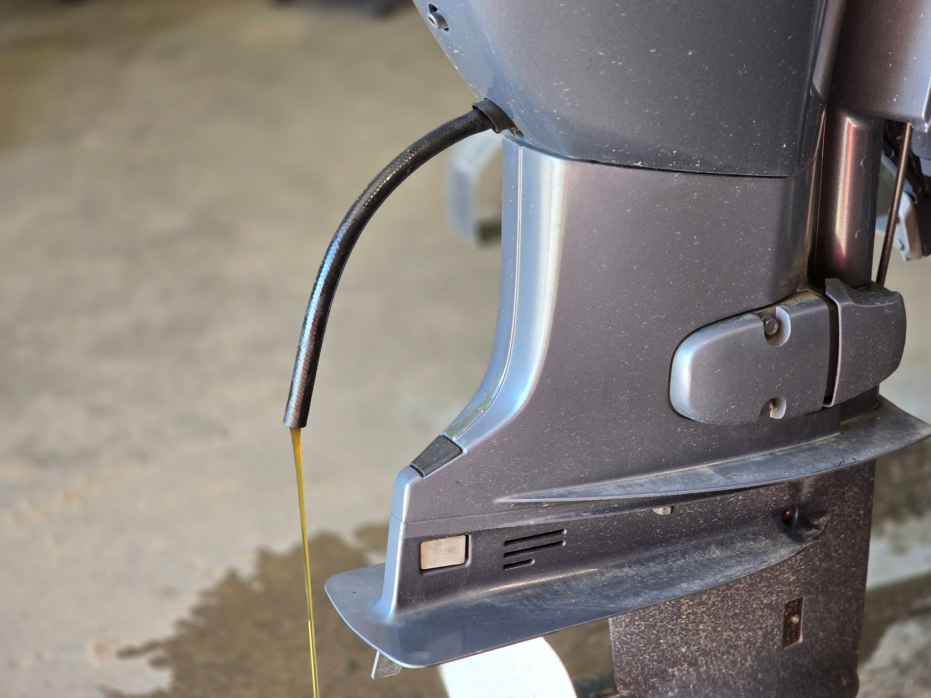 Yamaha 50 HP outboard crankcase oil draining during routine engine oil change service at Anchor Marine boat repair shop in Menomonie Wisconsin serving the Eau Claire area