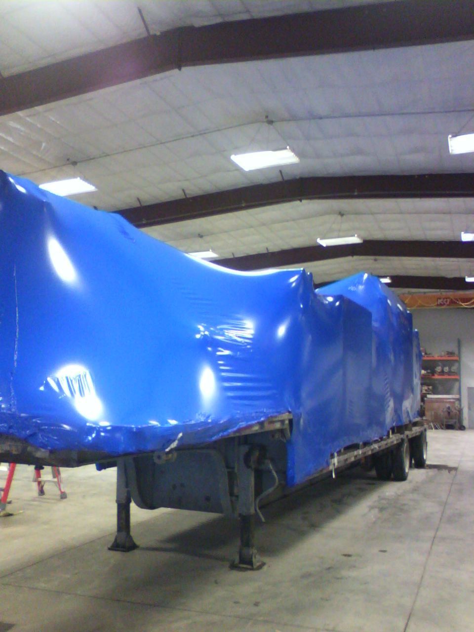 A trailer is wrapped in blue plastic