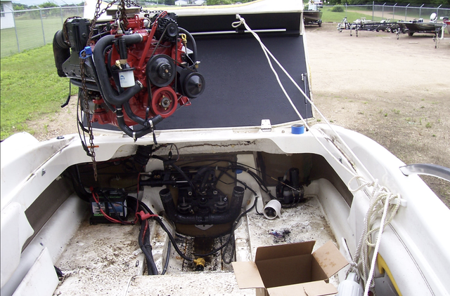 A boat with the engine removed and a box on the floor
