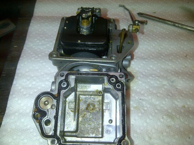 A carburetor is sitting on a paper towel on a table.