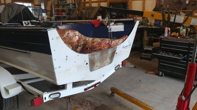 A boat is sitting on a trailer in a garage.