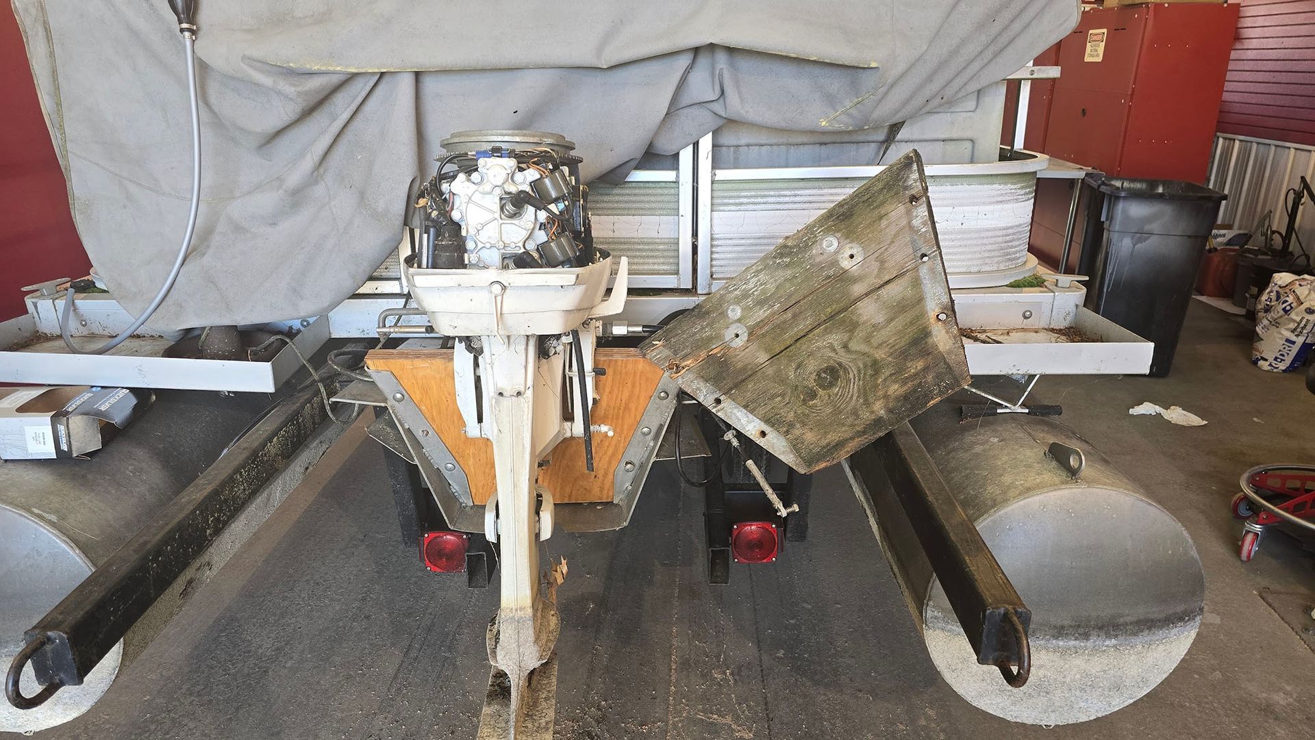 A boat with a motor attached to it is sitting in a garage