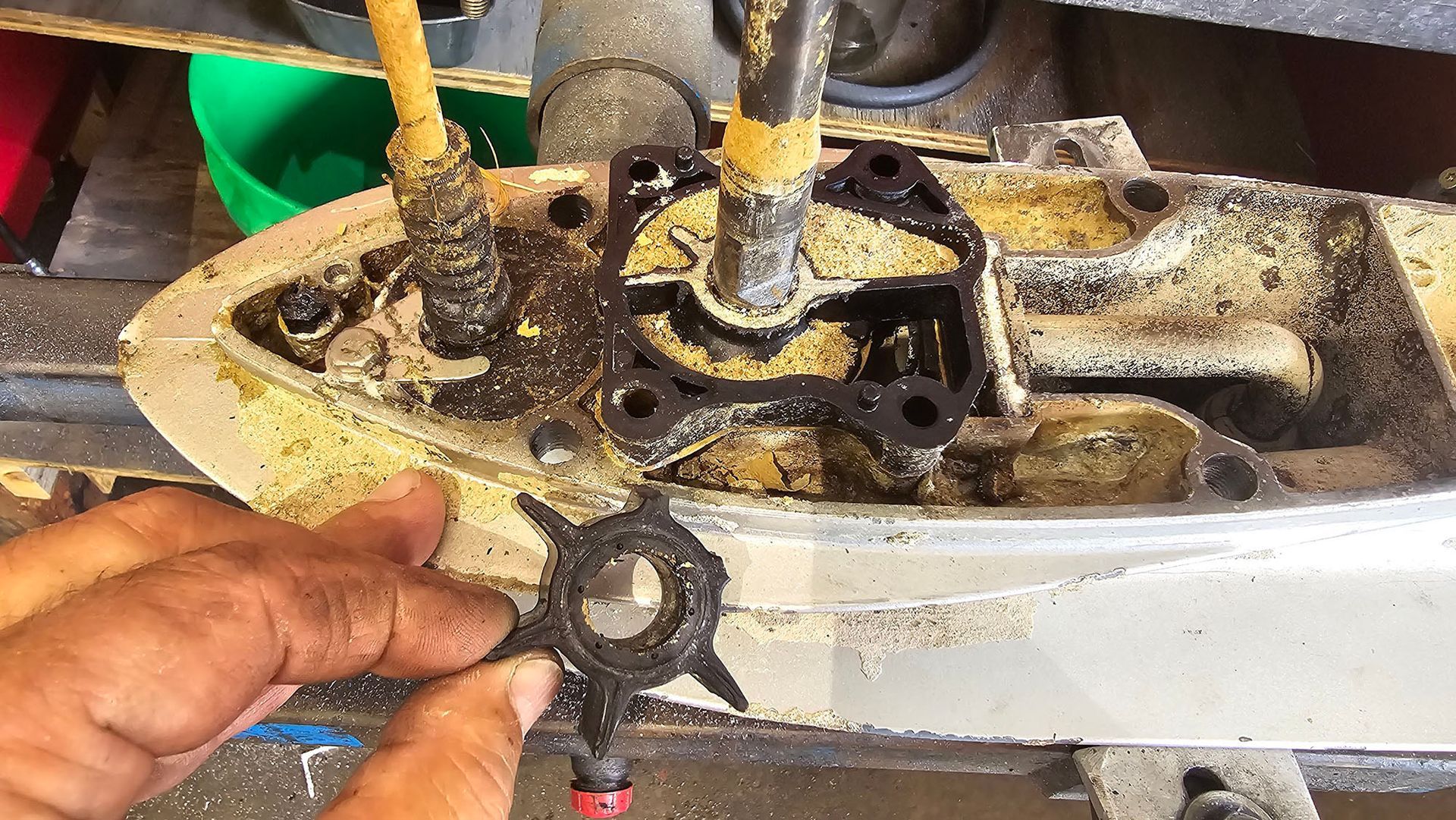 A person is working on a boat engine in a garage.