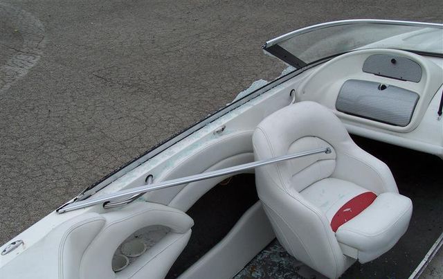 A white boat with a red cushion on the seat