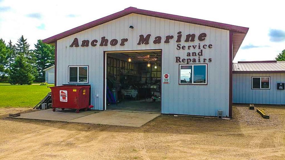 A white building with the words anchor marine service and repairs on it