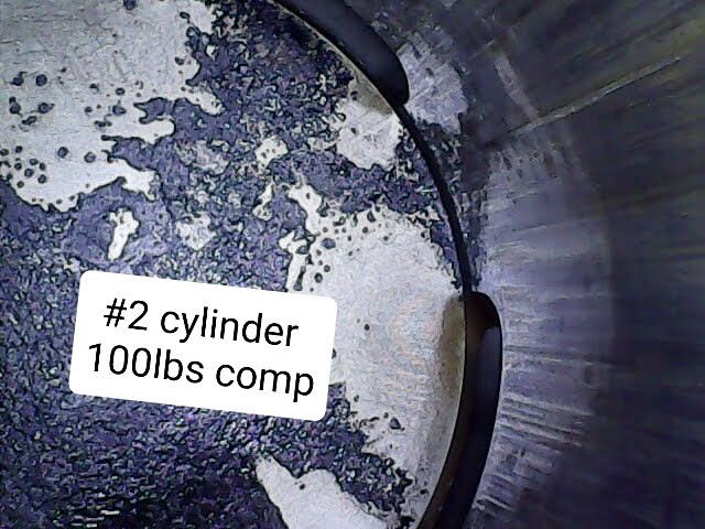 A close up of a cylinder that says # 2 cylinder 100lbs comp
