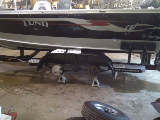 A lund boat is on a trailer in a garage