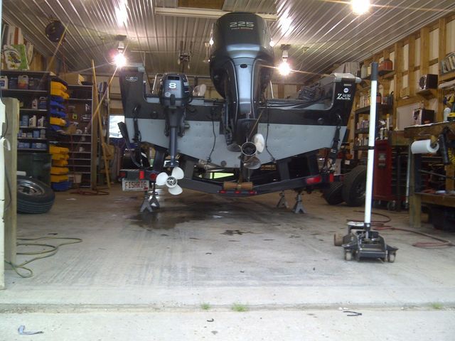 A boat is sitting in a garage with a propeller attached to it