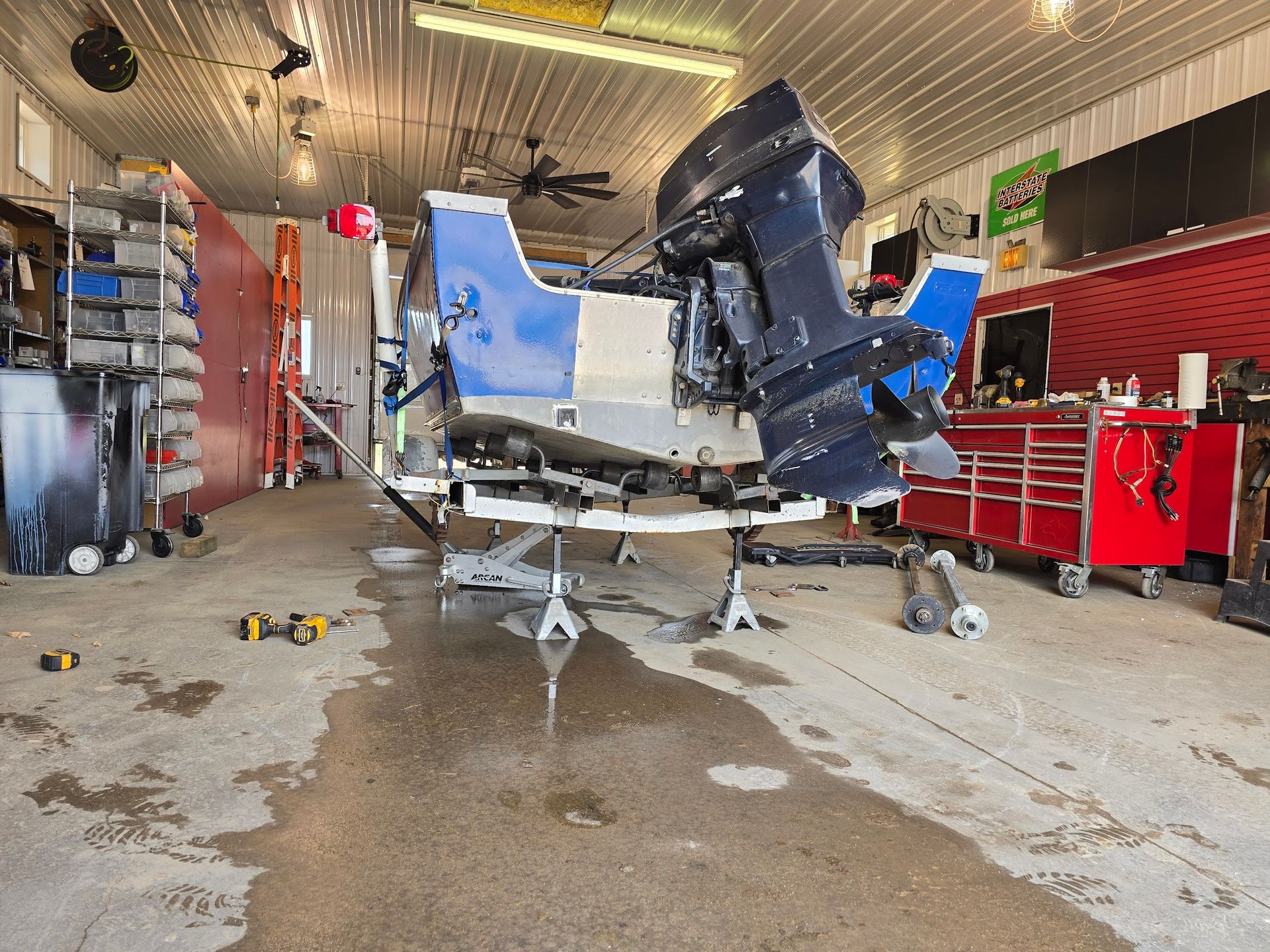 Boat trailer axle replacement at Anchor Marine in Menomonie Wisconsin with fishing boat lifted for suspension and axle repair service near Lake Menomin and Lake Tainter
