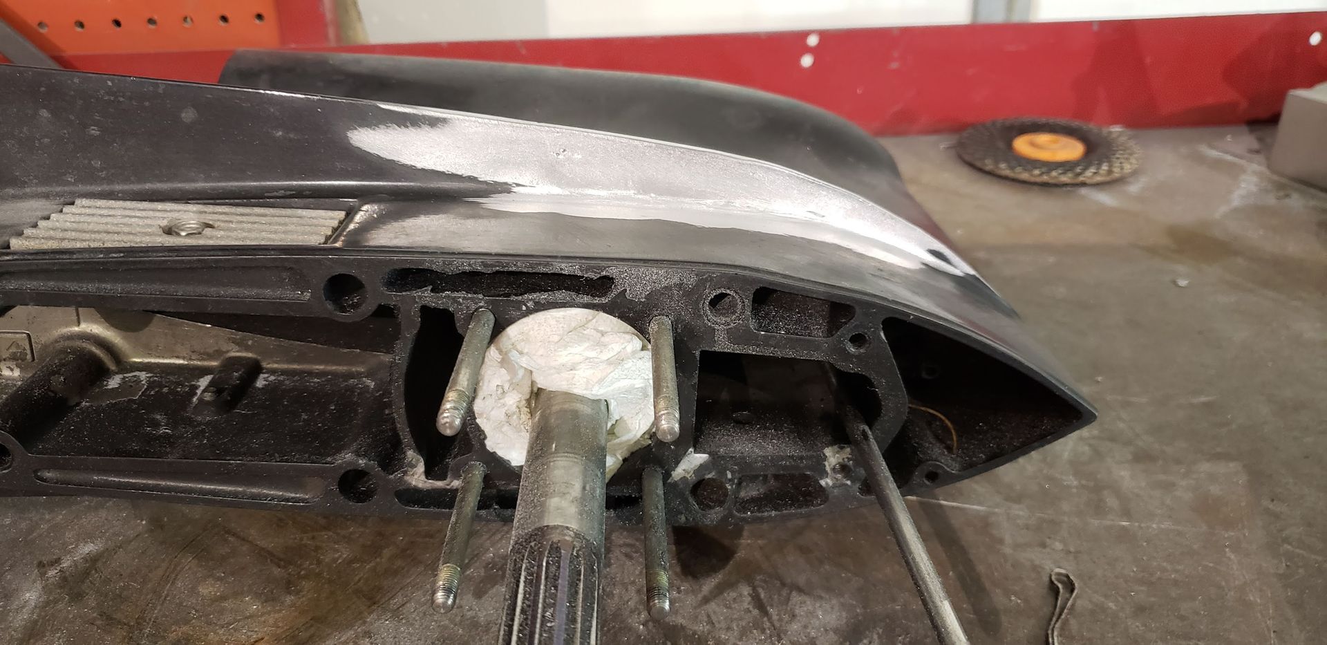 Force outboard anti-ventilation plate after aluminum welding repair and grinding to restore original shape at Anchor Marine boat repair shop in Menomonie Wisconsin serving the Eau Claire area