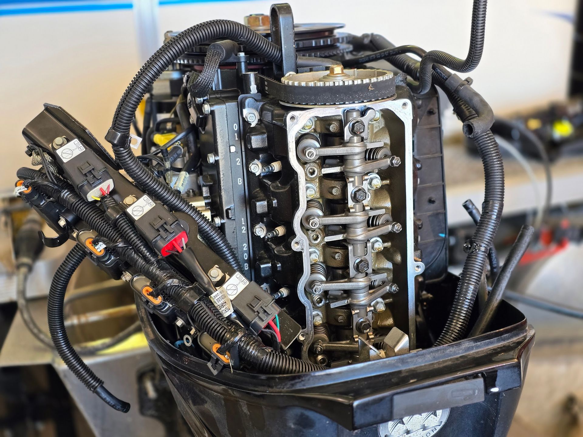 Mercury 60 HP four-stroke outboard engine with valve cover removed during valve clearance adjustment and routine maintenance service at Anchor Marine boat repair shop in Menomonie Wisconsin serving the Eau Claire area