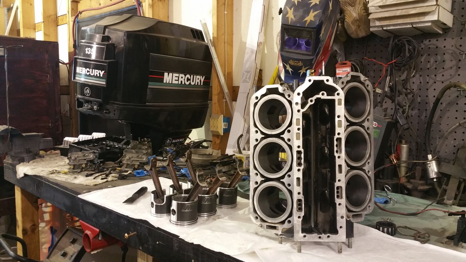 Mercury V6 outboard engine block with pistons and connecting rods during powerhead rebuild at Anchor Marine boat repair shop in Menomonie Wisconsin serving the Eau Claire area