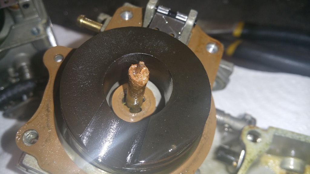 Heavy varnish and fuel deposits inside an outboard carburetor component during fuel system repair at Anchor Marine in Menomonie Wisconsin serving the Eau Claire boating area