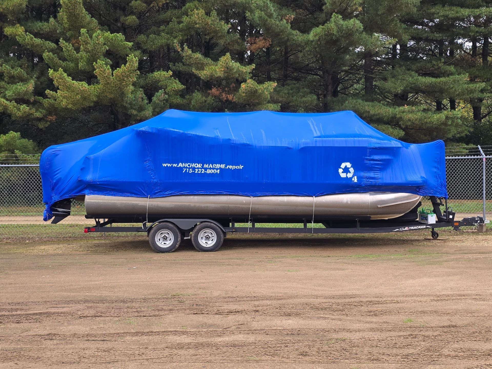 Pontoon boat shrink wrapped for winter storage with Anchor Marine branding in Menomonie Wisconsin