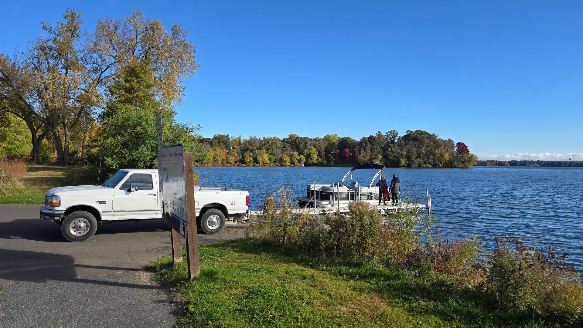 spring pontoon boat delivery to Lake Menomin in Menomonie Wisconsin showing launch at boat landing with insured transport service near Eau Claire