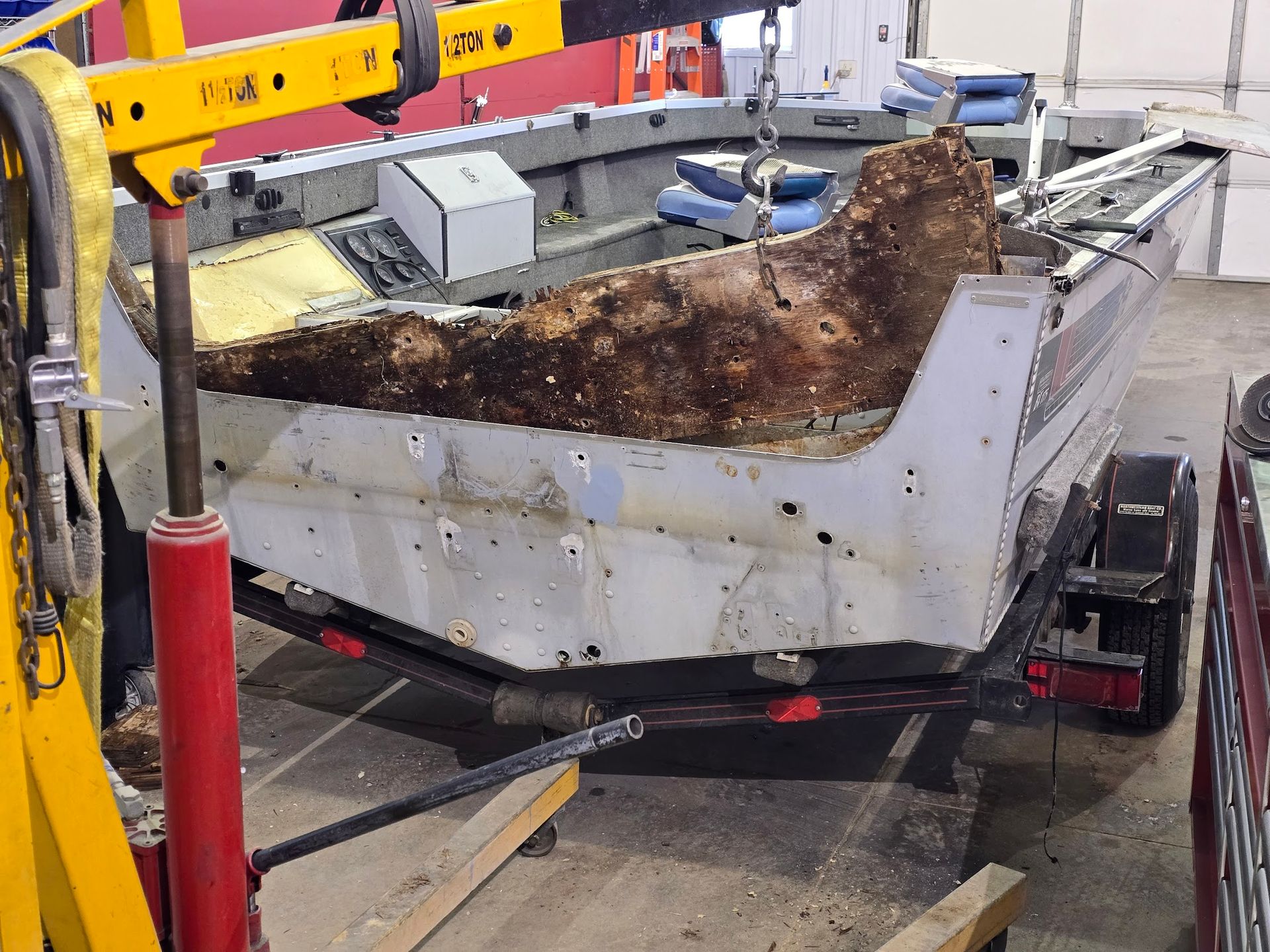 Rotten transom being removed from a Sea Nymph aluminum fishing boat during transom repair at Anchor Marine in Menomonie Wisconsin serving the Eau Claire and Chippewa Valley area