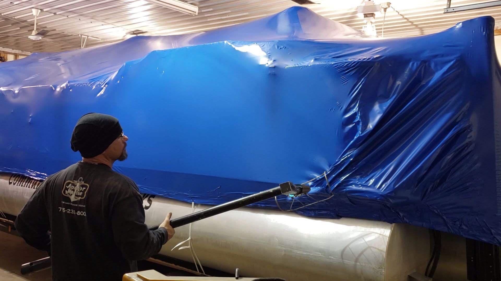 Doug Dominick at Anchor Marine shrink wrapping a boat for winter storage using marine shrink wrap in Menomonie Wisconsin