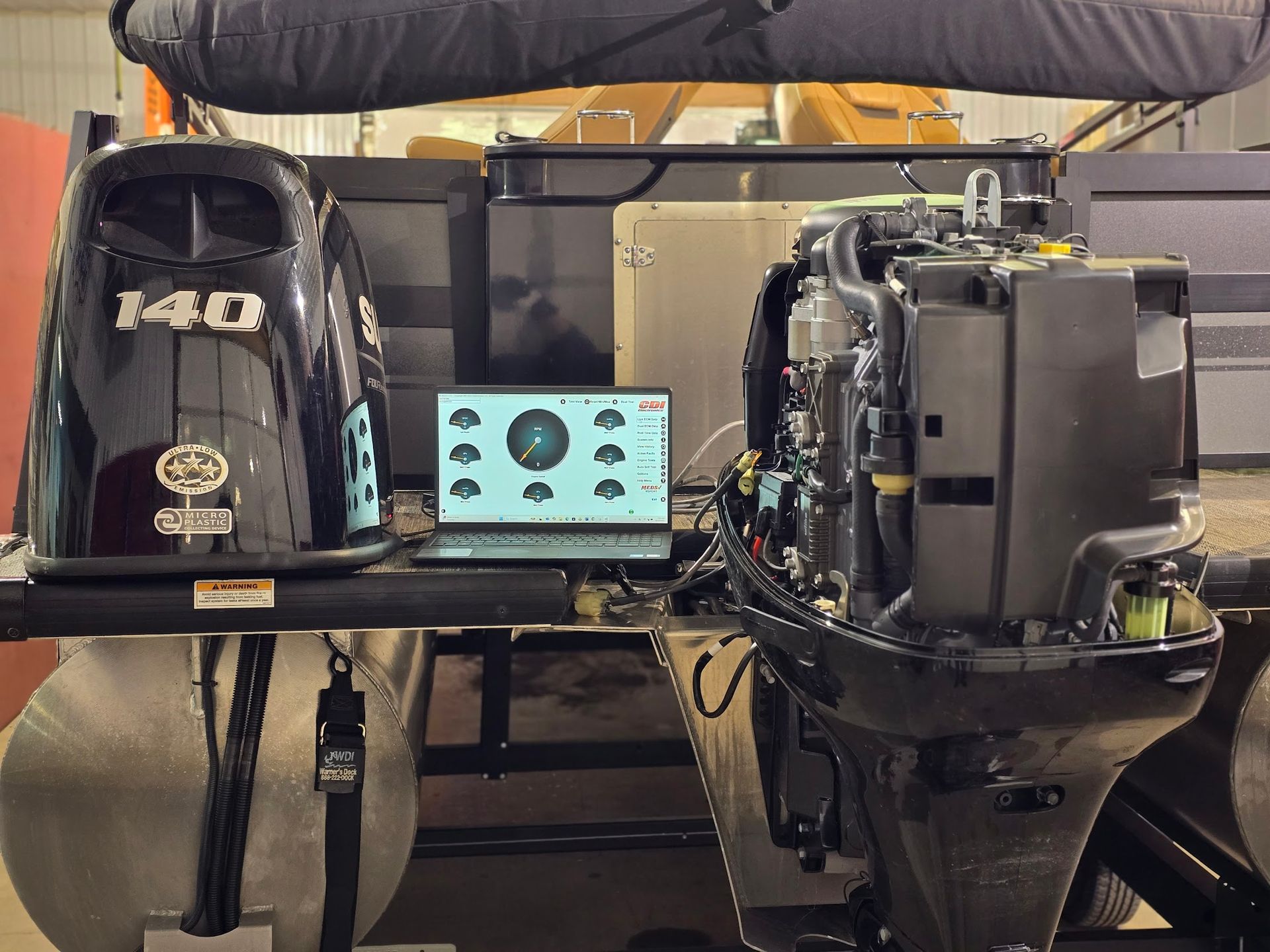 Suzuki 140 outboard engine connected to CDI Electronics diagnostic software for engine testing at Anchor Marine boat repair shop in Menomonie Wisconsin serving the Eau Claire area
