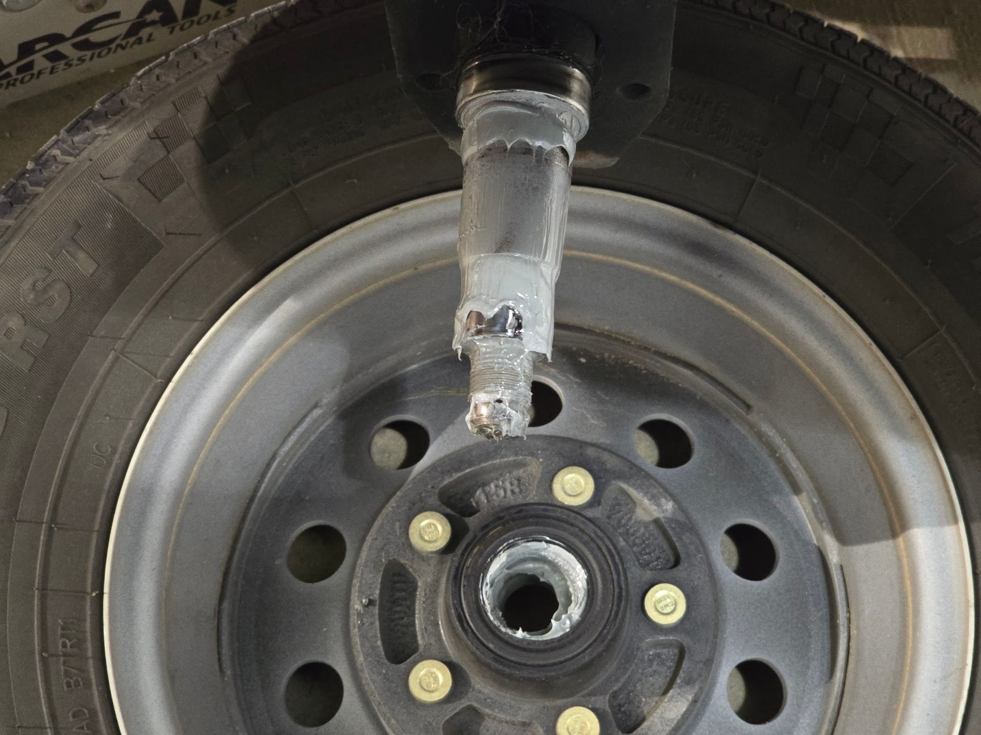 Water intrusion damage to boat trailer bearings and spindle shown during repair at Anchor Marine in Menomonie Wisconsin with failed hub and bearing components requiring replacement