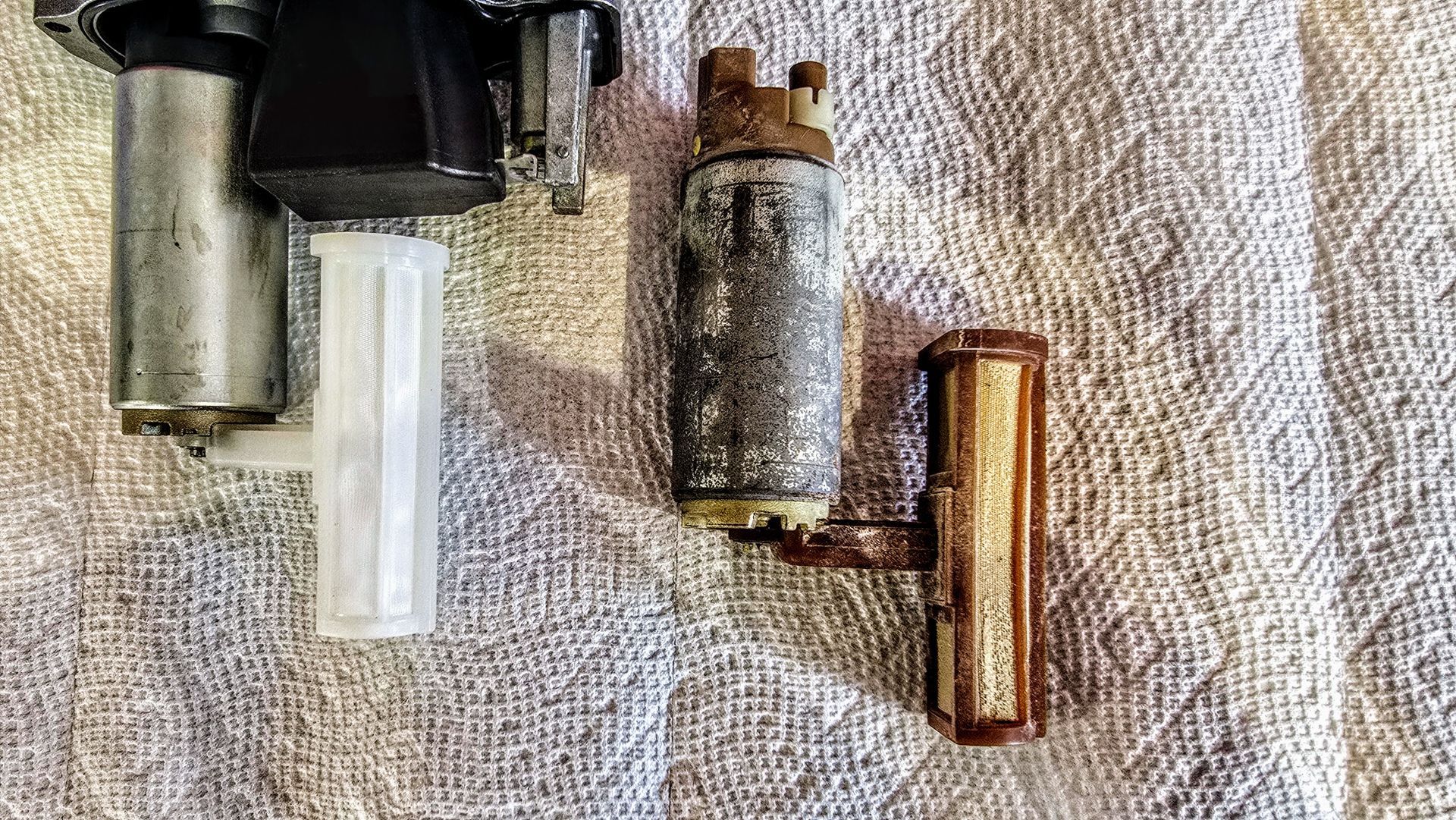 Disassembled Yamaha outboard fuel pump showing internal filter and electric pump from a low-hour engine during fuel system repair at Anchor Marine in Menomonie Wisconsin serving the Eau Claire boating area
