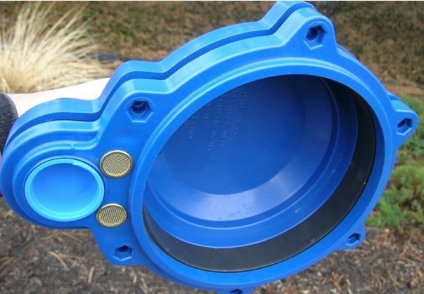 Blue plastic mechanical cover with a large round opening and two brass inserts on a furry surface