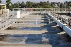 Industrial wastewater treatment tanks with walkways and pipes outdoors
