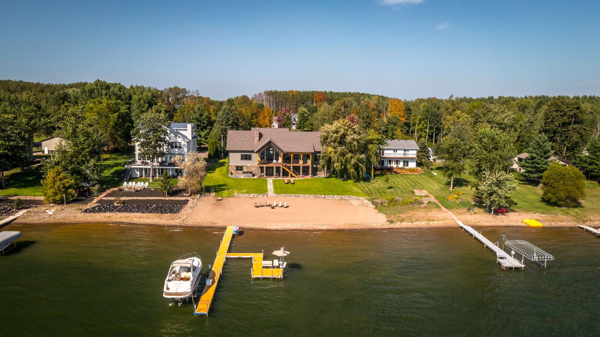 Aerial view of lakefront homes with docks and boats on the water.