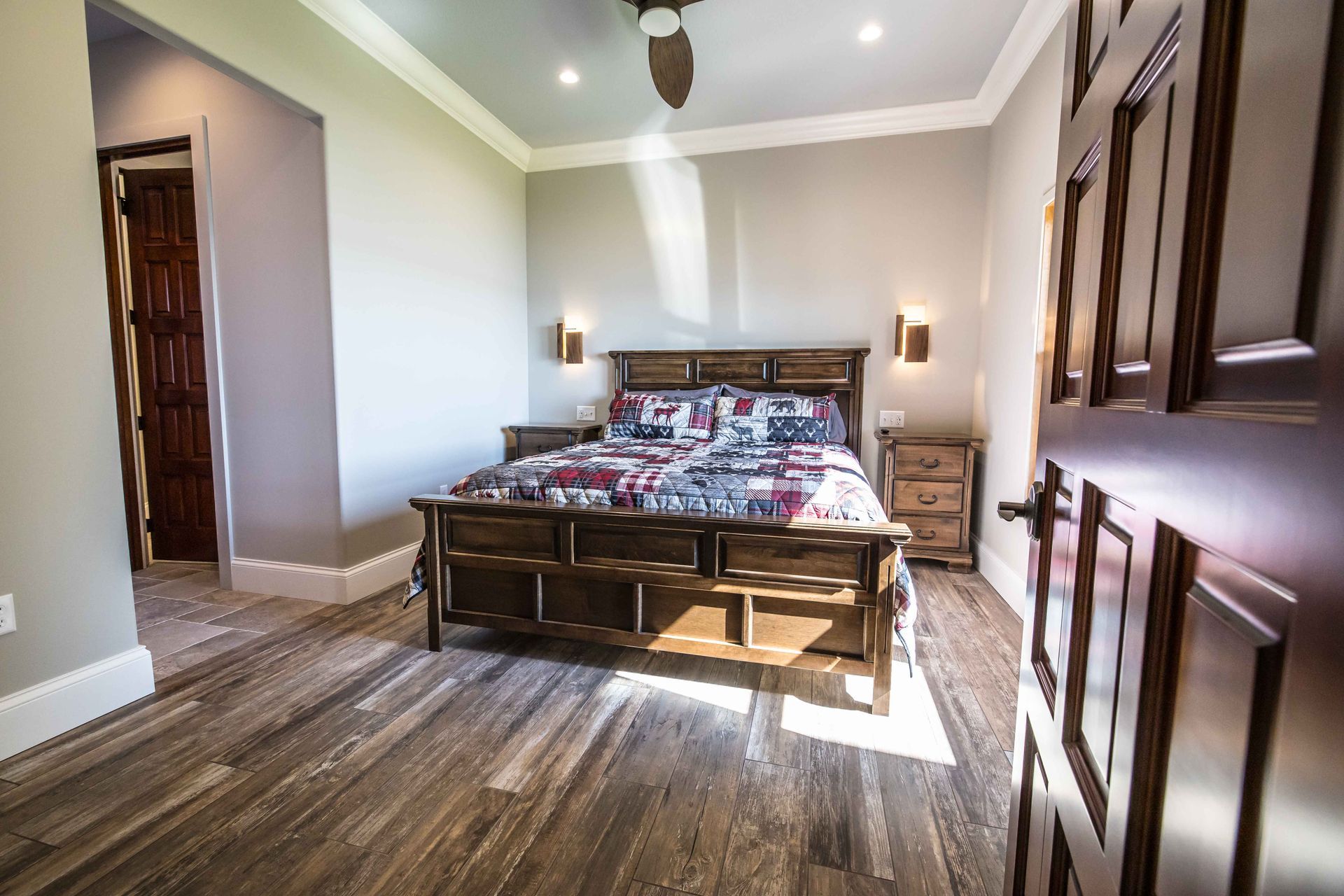 Bedroom with wooden furniture, hardwood floors, and gray walls.
