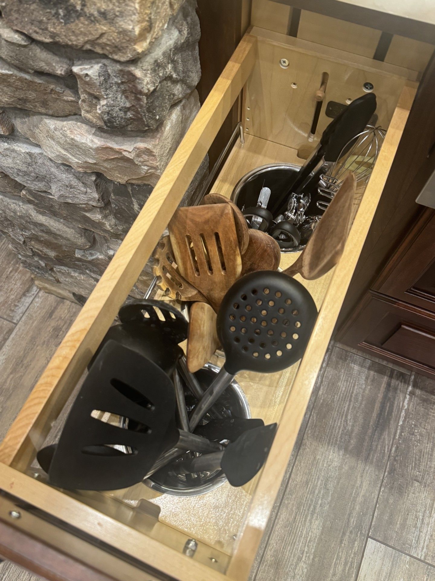 Open kitchen drawer filled with various cooking utensils.