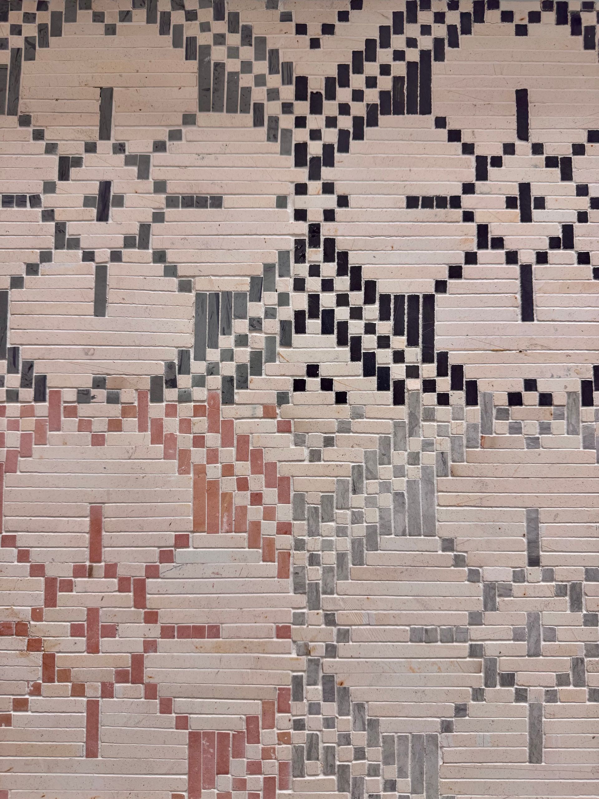Patterned woven textile with geometric diamond motifs in beige, black, and muted red.