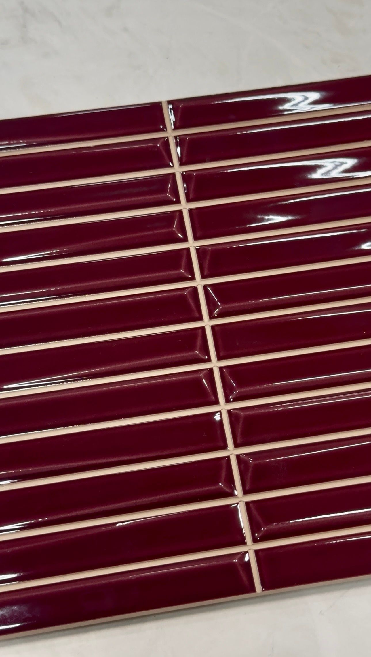 Maroon slatted surface with white trim lines, viewed at an angle