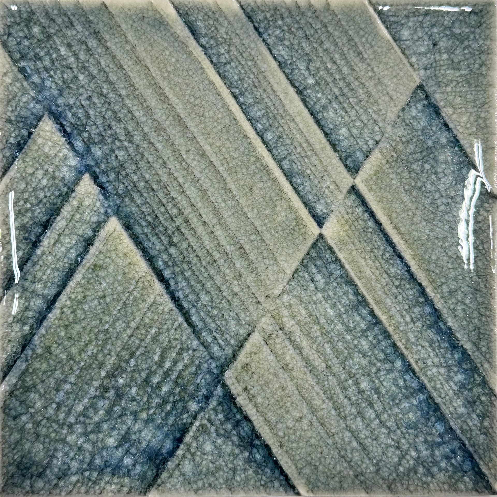Close-up of woven fabric with diagonal gray-green and blue textured stripes.