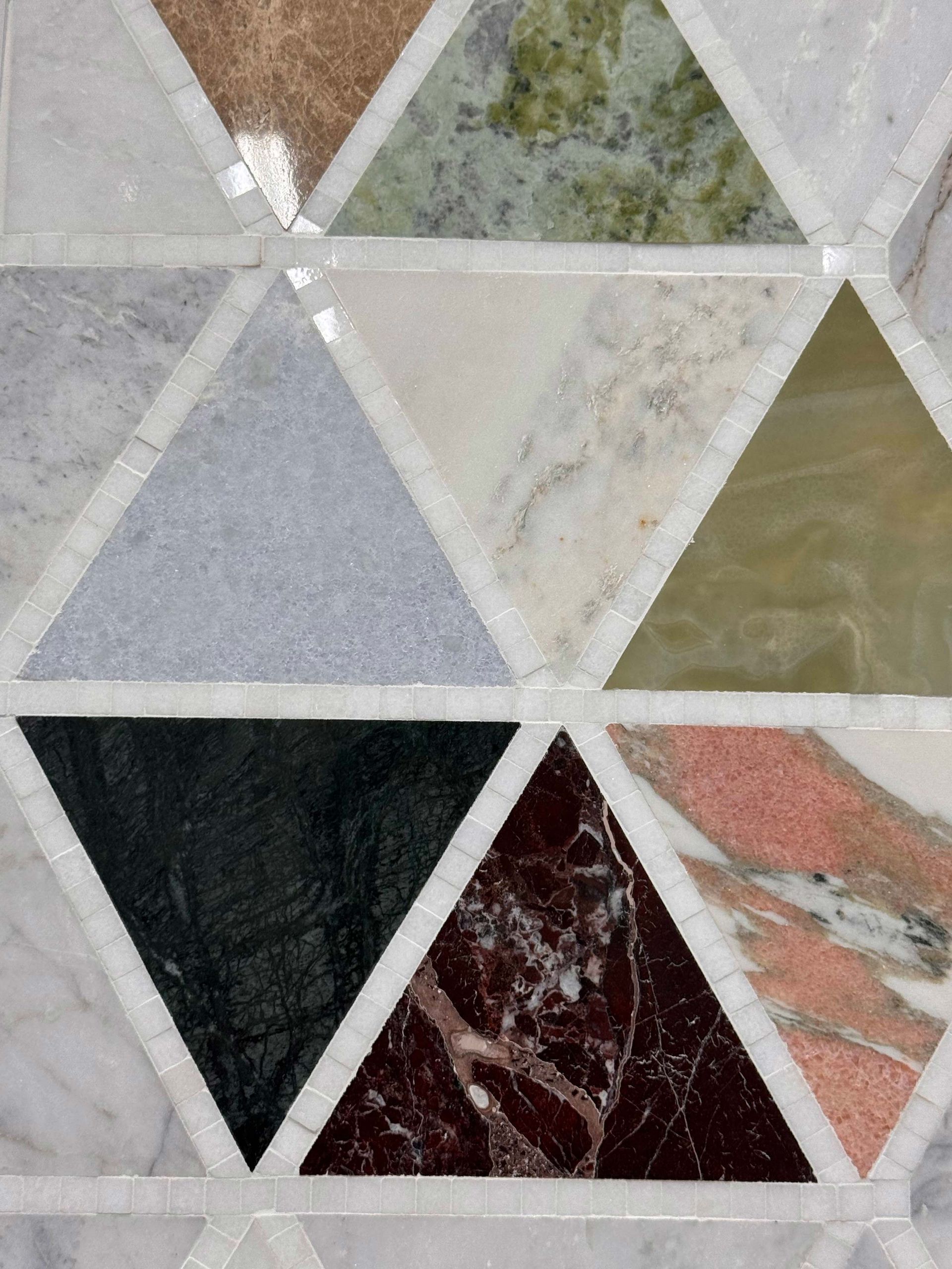 Abstract geometric wall tiles in gray, white, green, black, and maroon triangles