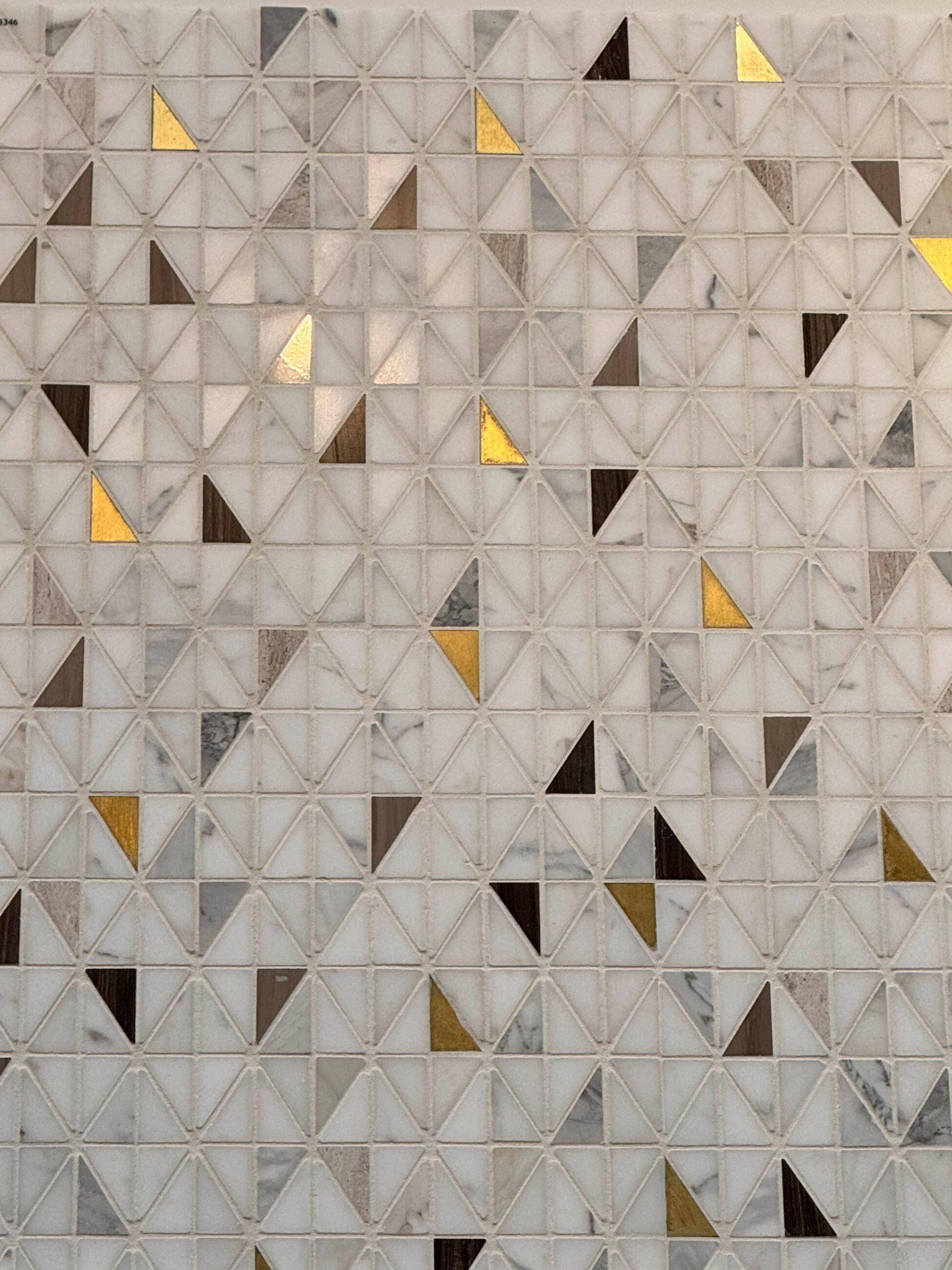 Geometric quilt pattern of gray, beige, and yellow triangles arranged in a tiled grid