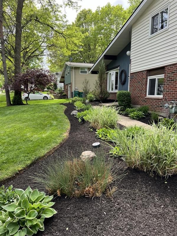 A house with a lush green lawn and a walkway leading to it.