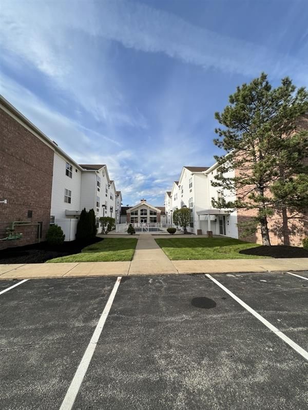 A parking lot in front of a row of apartment buildings
