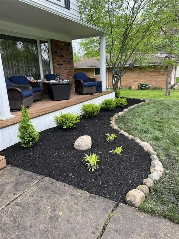 There is a porch with chairs and a table on it.