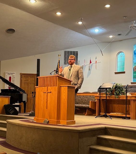 A man is giving a speech at a podium in a church