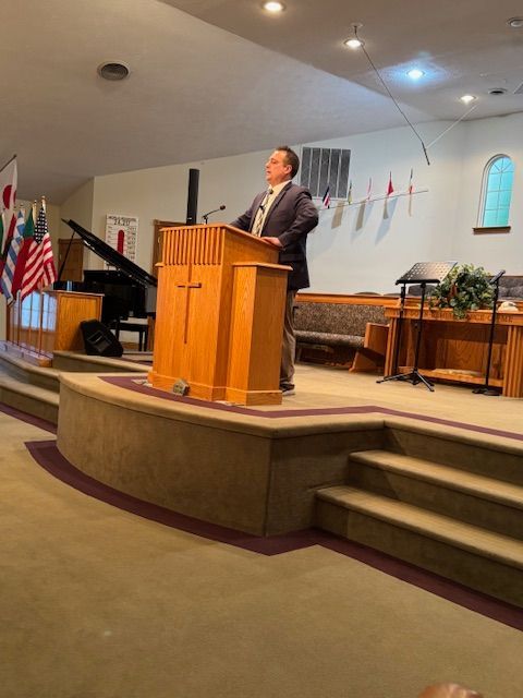 A man is giving a speech at a podium in a church