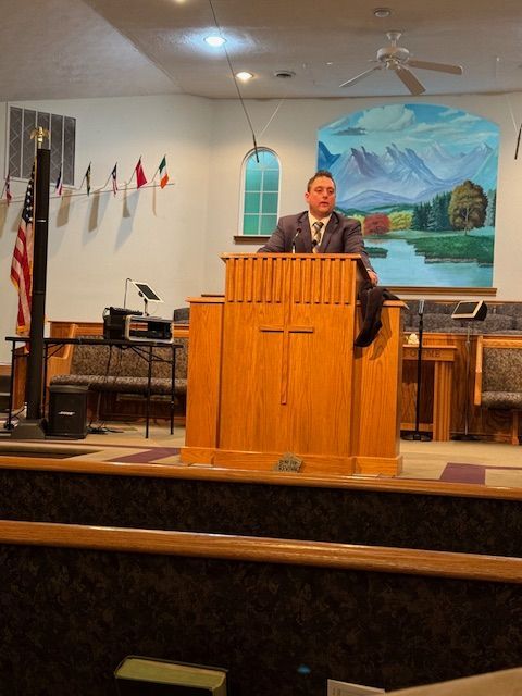 A man is giving a speech at a podium in a church