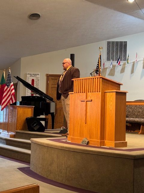A man stands at a podium in a church