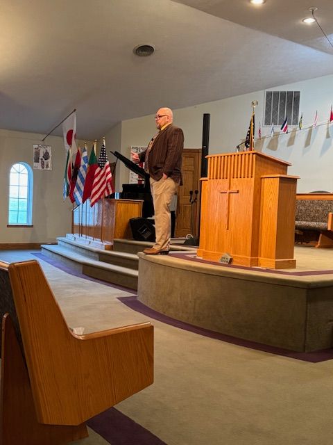 A man is standing at a podium in a church