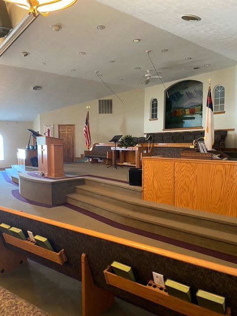 the inside of a church with a podium and bible racks