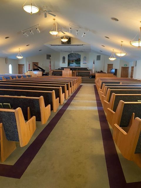 the inside of a church with rows of wooden benches